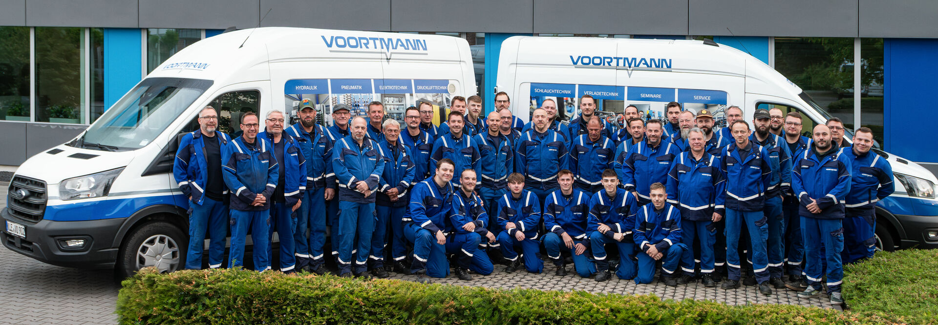 Bild der Servicetechniker von VOORTMANN vor zwei Servicefahrzeugen